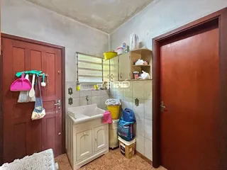 Interior de um banheiro com paredes de azulejo e portas de madeira.