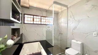 Foto de um banheiro moderno com revestimento de mármore e box de vidro.
