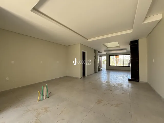 Ambiente interno de uma sala com piso de concreto e paredes brancas.