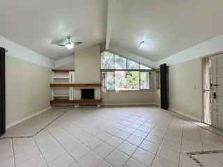 Sala de estar ampla com piso de cerâmica e grande janela.