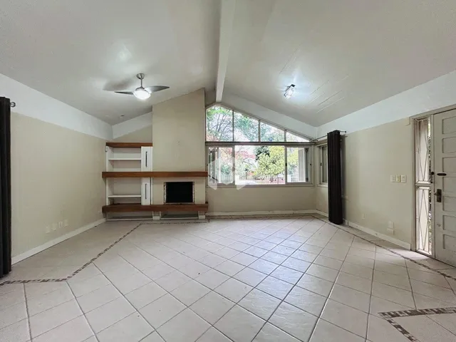 Sala de estar ampla com piso de cerâmica e grande janela.
