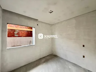 Foto de um cômodo com parede de tijolos exposta e piso de concreto.
