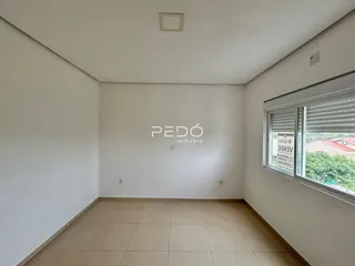 Ambiente interno de uma sala com piso de cerâmica e janela com vista externa.