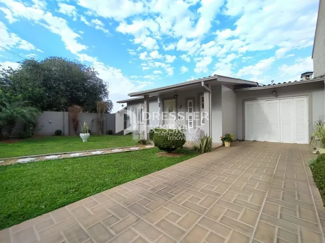 Fachada de uma residência com jardim e calçada em Lajeado, Brasil.