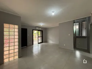 Interior de uma sala ampla com piso de cerâmica e paredes cinzas.