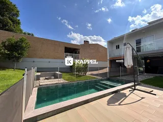 Foto da piscina externa com deck e área verde no quintal da propriedade.