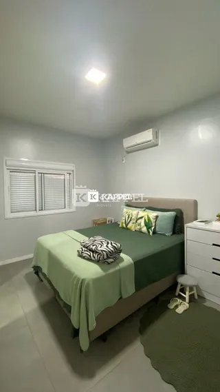 Quarto com cama e janela com persianas no interior da propriedade.