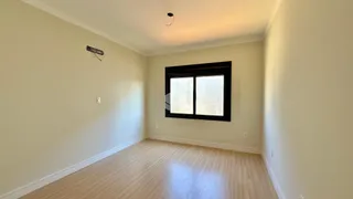 Ambiente interno de uma sala com piso de madeira e janela.