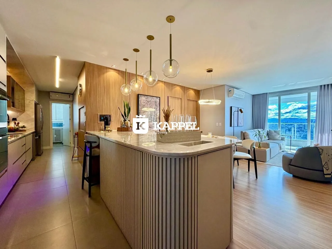 Ambiente moderno com cozinha integrada e sala de estar com vista para a paisagem.