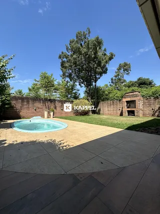 Foto da área externa com piscina e jardim em um imóvel.