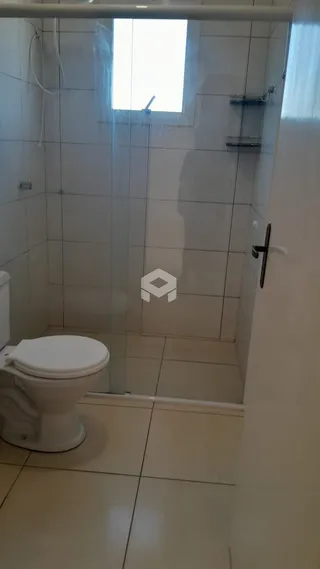 Foto de um banheiro com revestimento cerâmico e box de vidro.