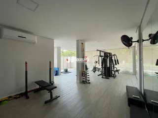 Ambiente interno amplo com piso claro e equipamentos de ginástica.