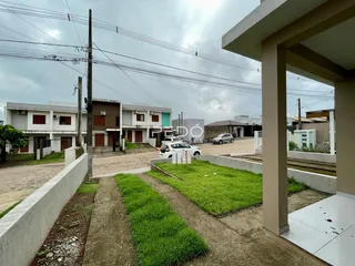 Vista externa de uma propriedade com jardim e área pavimentada.