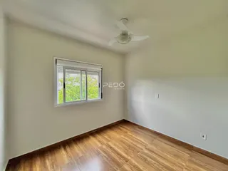 Sala de estar com piso de madeira e janela em um imóvel no Brasil.