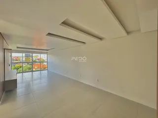 Corredor longo com piso de cerâmica e grande janela de uma residência.