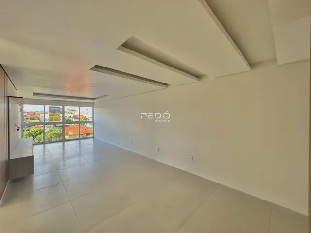 Corredor longo com piso de cerâmica e grande janela de uma residência.