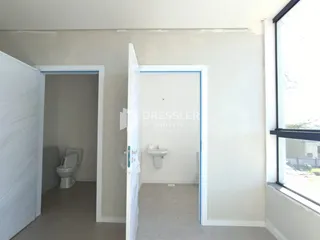 Vista de um corredor interno com acesso a banheiros.