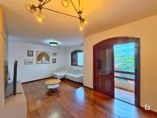 Quarto com piso de madeira e porta de vidro que dá acesso a uma área externa.