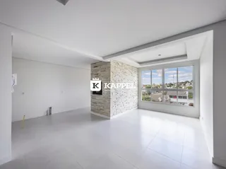 Uma sala ampla e clara com parede de pedra e grande janela com vista da cidade.