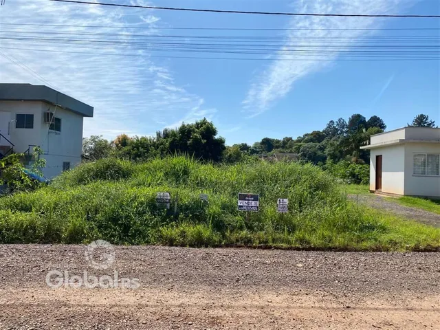 Vista externa de uma propriedade com vegetação densa no meio.