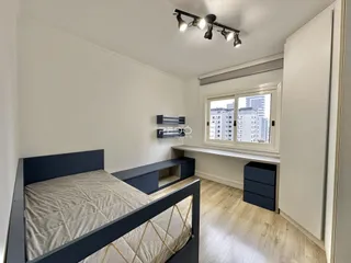 Quarto com cama e janela em apartamento.