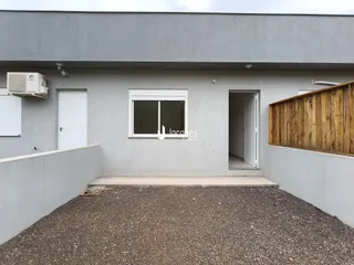 Fachada externa de uma residência em Lajeado, Brasil, com parede cinza e porta branca.