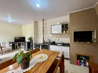 Imagem de uma sala de estar com cozinha e área de jantar em um imóvel no Brasil.
