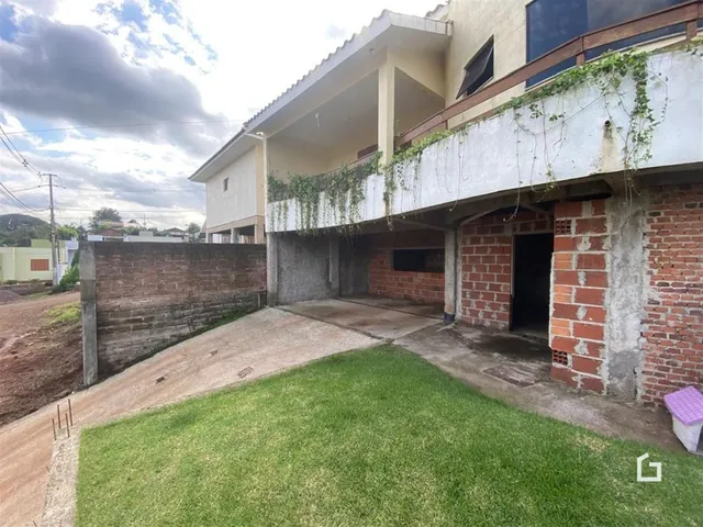 Fachada de um imóvel residencial em Lajeado, Brasil, com alvenaria de tijolo aparente e jardim.