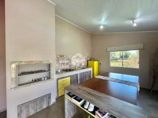 Foto de um ambiente interno de cozinha com armários amarelos e bancada de madeira.