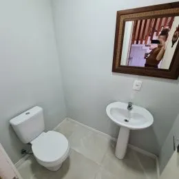 Foto de um banheiro com vaso sanitário branco e piso claro.