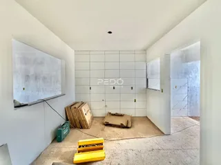Foto de um ambiente interno em construção com paredes de concreto exposto.