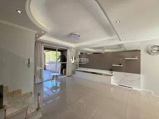 Sala de estar moderna com piso de porcelanato e grandes portas de vidro.