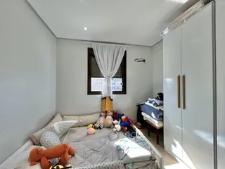 Quarto com cama e guarda-roupa em ambiente claro.