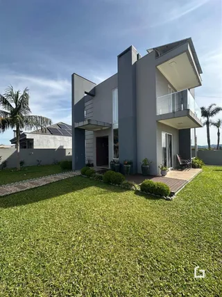 Fachada de uma casa moderna com jardim gramado em Lajeado, Brasil.