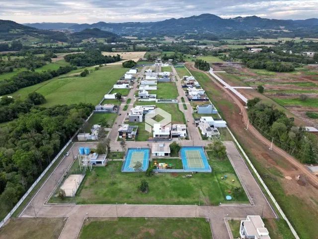 Vista aérea de um terreno com áreas verdes e piscina em Lajeado, Brasil.