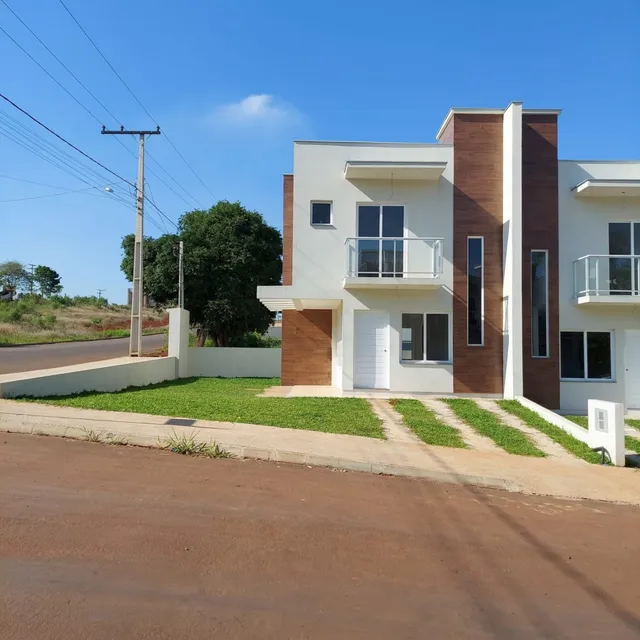 Fachada de uma casa moderna em Lajeado, Brasil, com paredes brancas e detalhes em madeira.