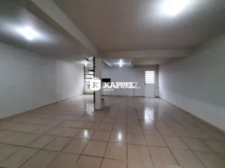 Hall de corredor com piso de cerâmica e escadaria visível.
