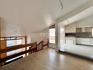 Sala de estar com piso de madeira e ambiente aberto.