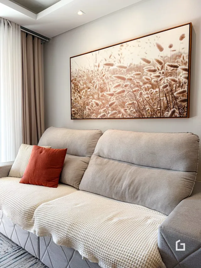Sala de estar com sofá e quadro na parede.
