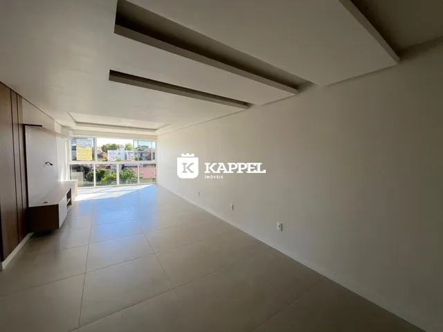 Vista de um corredor amplo com piso de cerâmica e portas de vidro que dão acesso ao exterior.