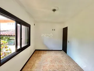 Ambiente interno com piso de cerâmica e janela grande.