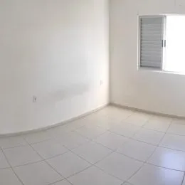 Foto do piso e parede branca de um ambiente interno de um imóvel.