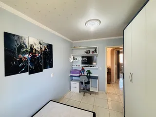 Quarto com parede azul e armário embutido na lateral da imagem.