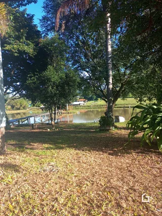 Paisagem externa mostrando gramado, árvores e um corpo d'água.