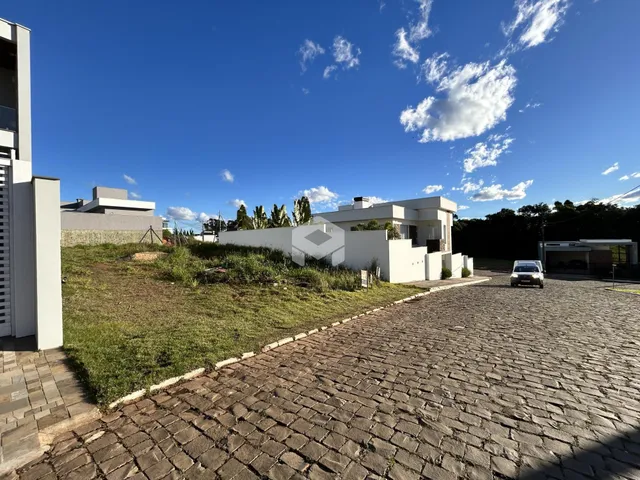 Fachada de uma casa moderna em Lajeado, Brasil, com jardim e entrada pavimentada.