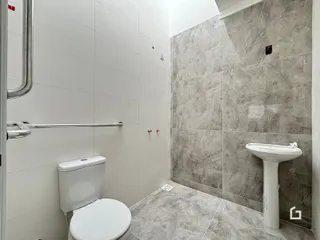 Foto de um banheiro com revestimento cerâmico nas paredes e piso.