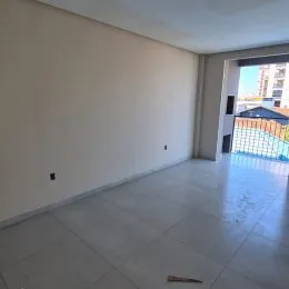 Vista interna de um ambiente com piso claro e paredes brancas.