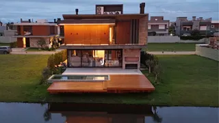 Fachada moderna de uma casa em Lajeado, Brasil, com jardim e deck de madeira.