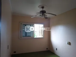 Foto interna de um cômodo com paredes claras e uma janela.