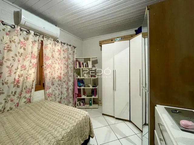 Quarto com cama e guarda-roupa em ambiente claro.